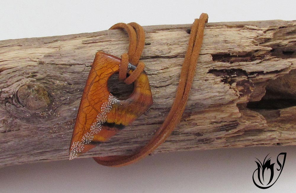 Polymer clay tiger eye and crackle pendant on brown suede cord.